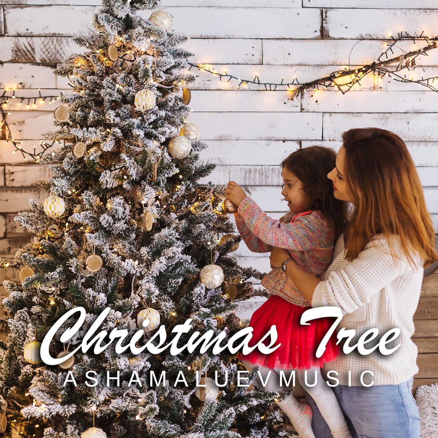 Cover art of the music track 'Christmas Tree' by AShamaluevMusic, which shows the woman and child decorating a Christmas tree with lights and ornaments against a wooden wall.