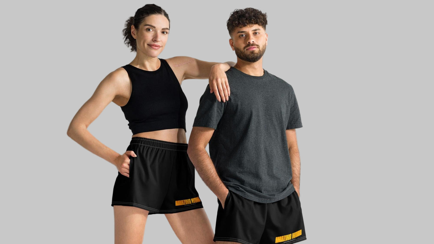 Two people wearing black athletic shorts with print 'Amazing World' and 'AShamaluevMusic' logo a gray background