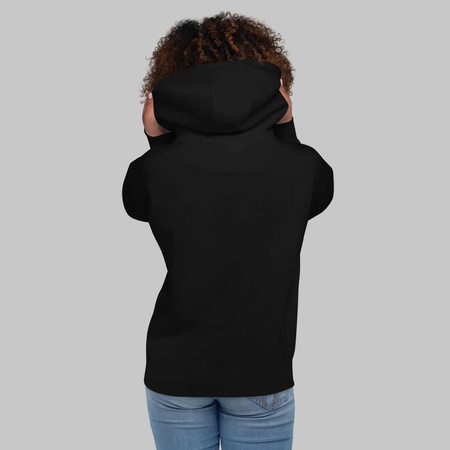 Woman wearing a black premium hoodie from behind on a gray background