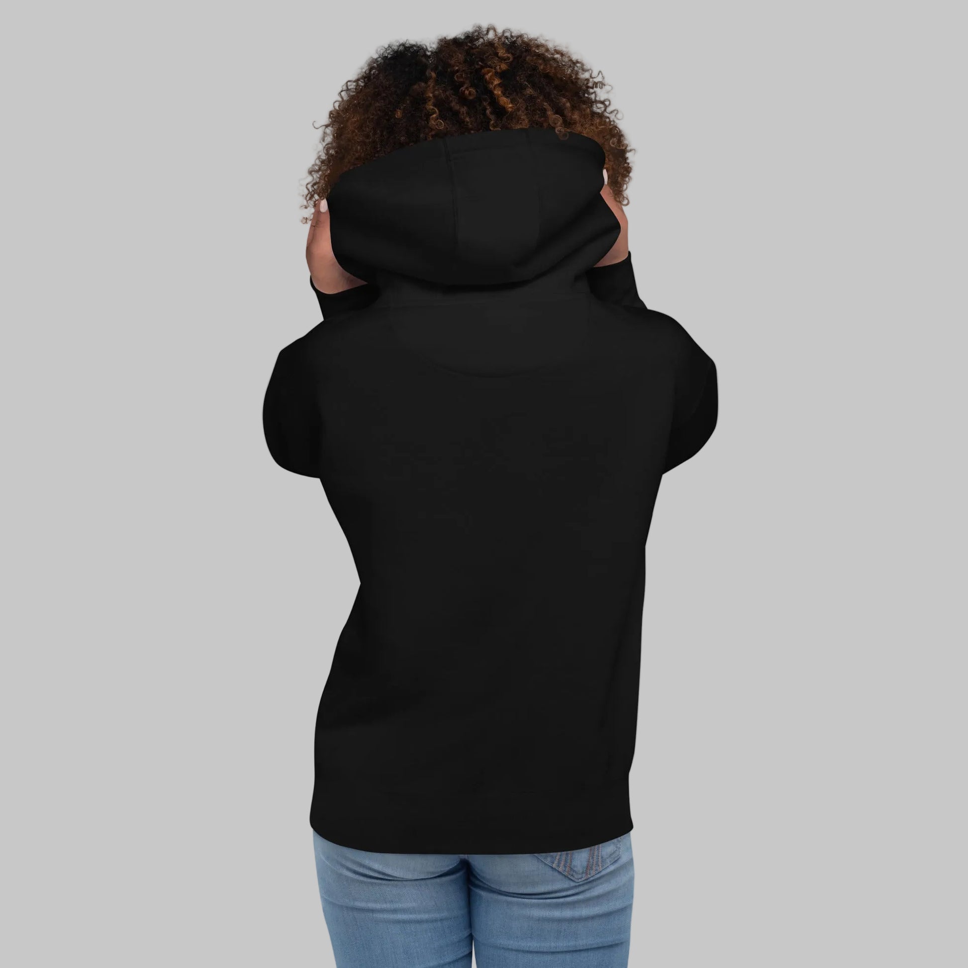 Woman wearing a black premium hoodie from behind on a gray background