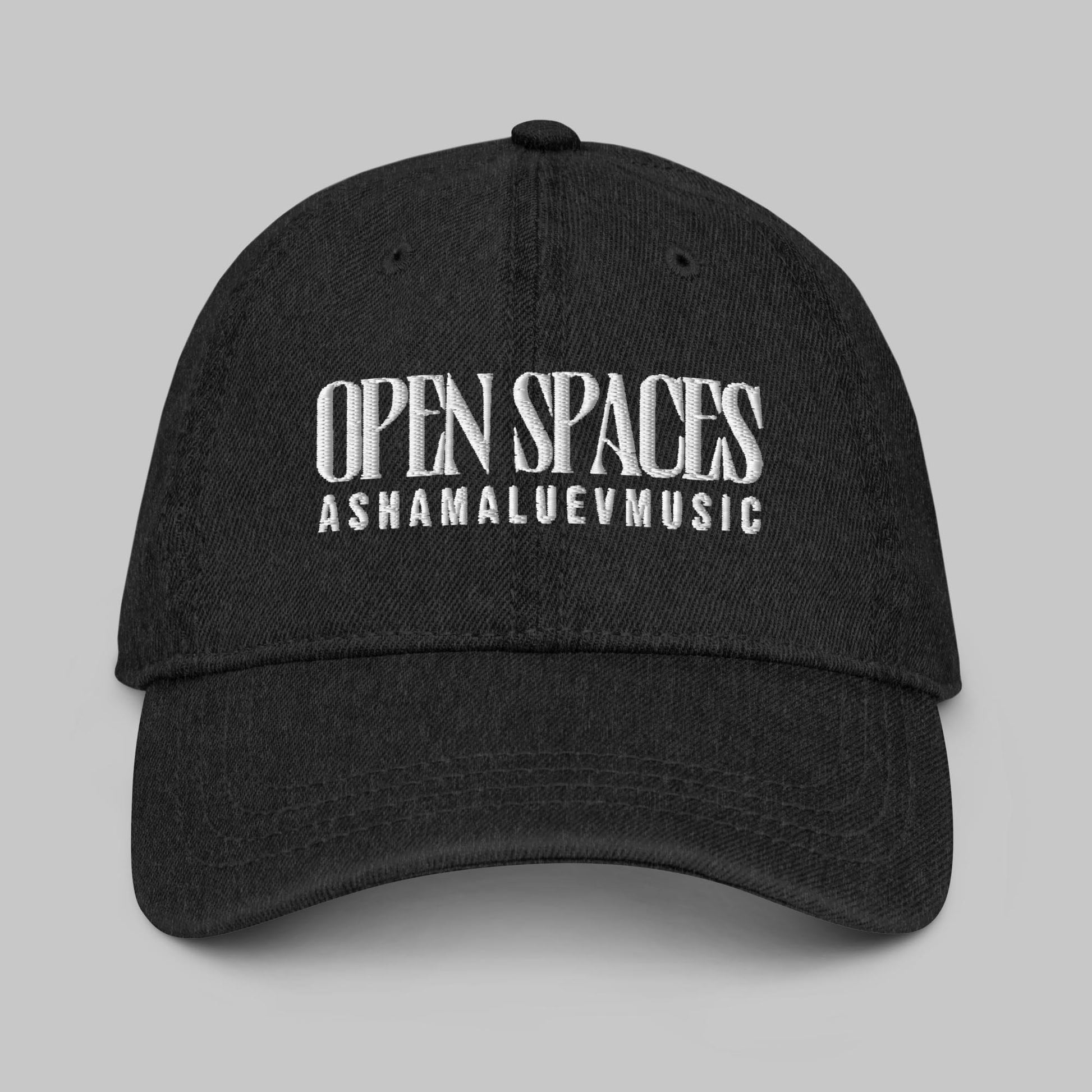 Black denim cap with white text 'Open Spaces' and 'AShamaluevMusic' on a gray background