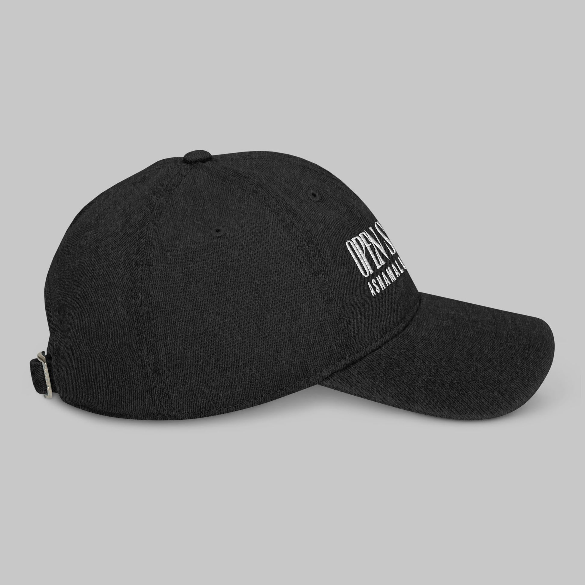 Black denim cap with white text 'Open Spaces' and 'AShamaluevMusic' on a gray background