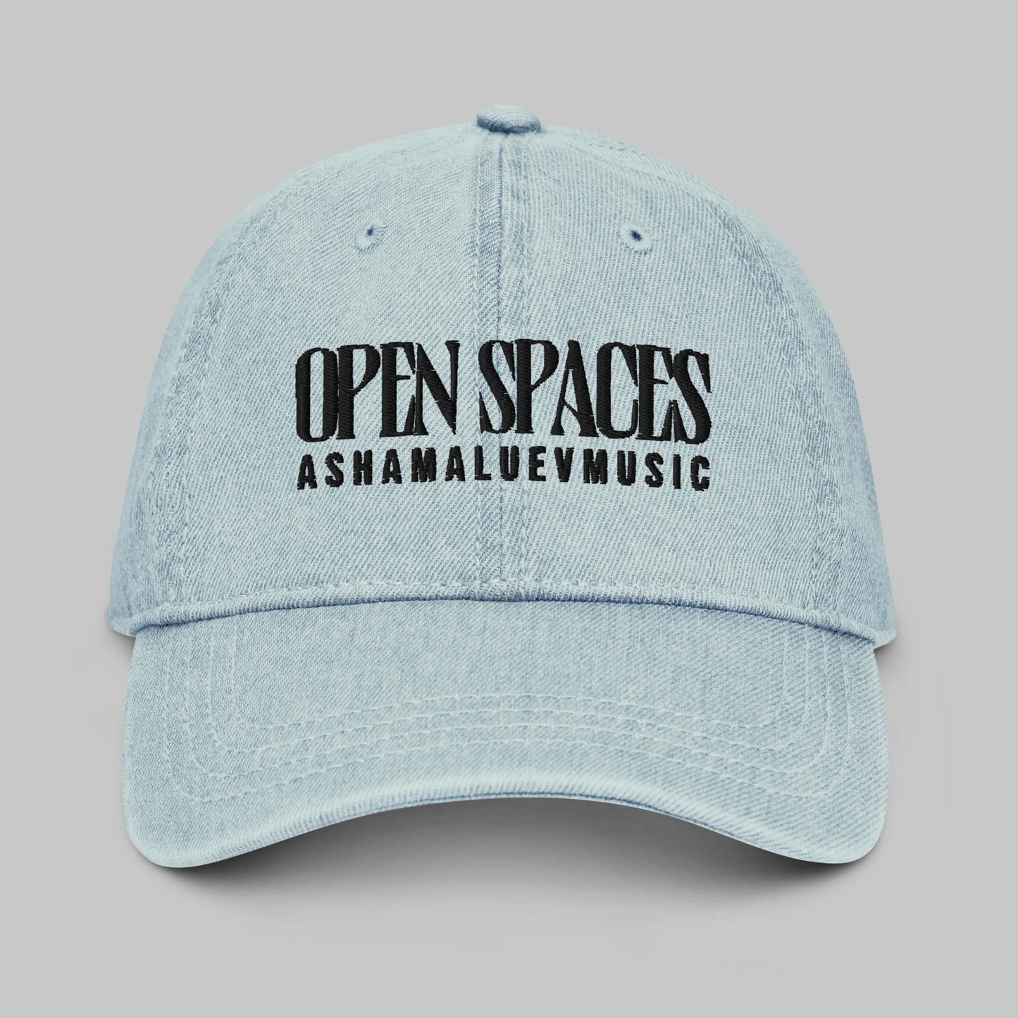 Light blue denim cap with black text 'Open Spaces' and 'AShamaluevMusic' on a gray background