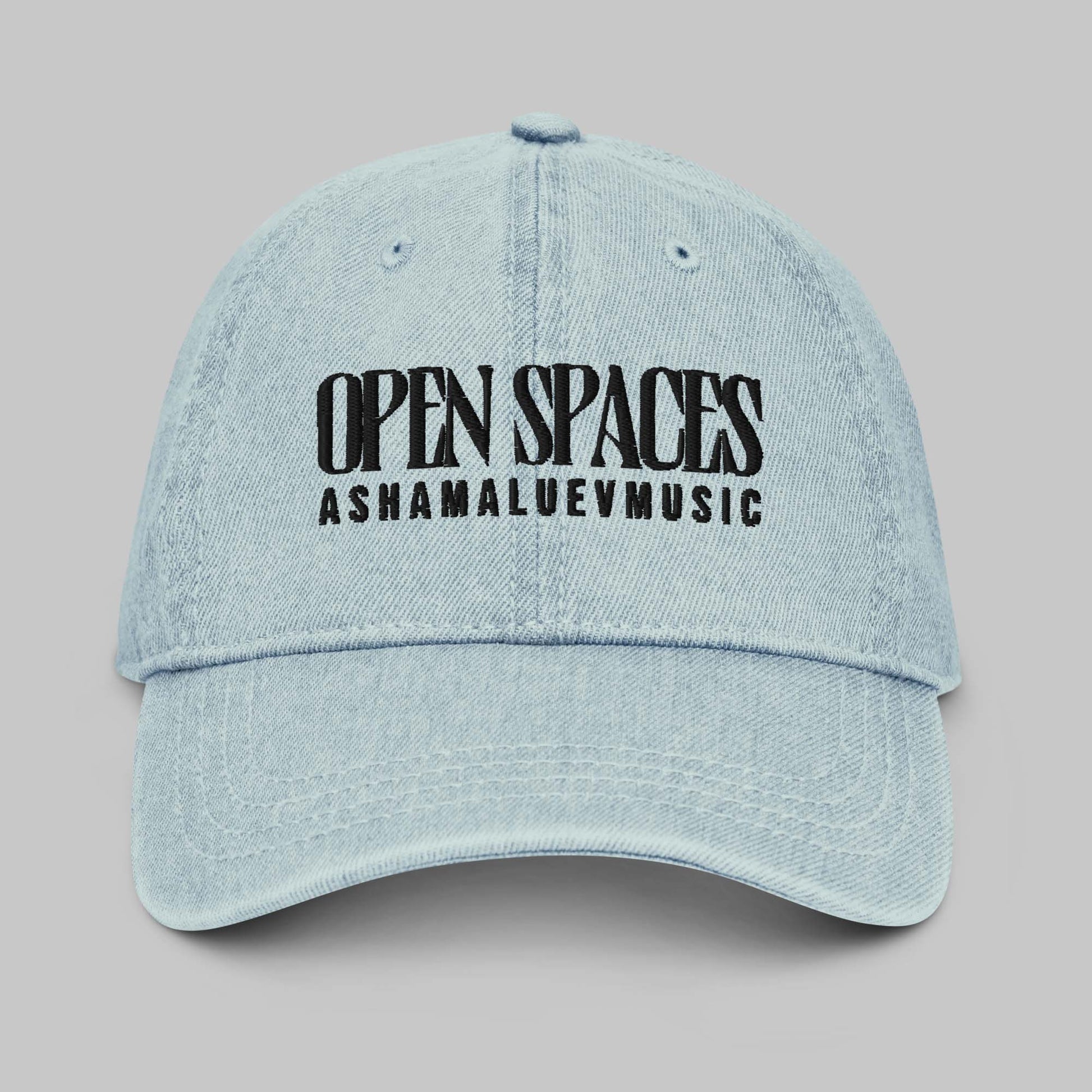 Light blue denim cap with black text 'Open Spaces' and 'AShamaluevMusic' on a gray background