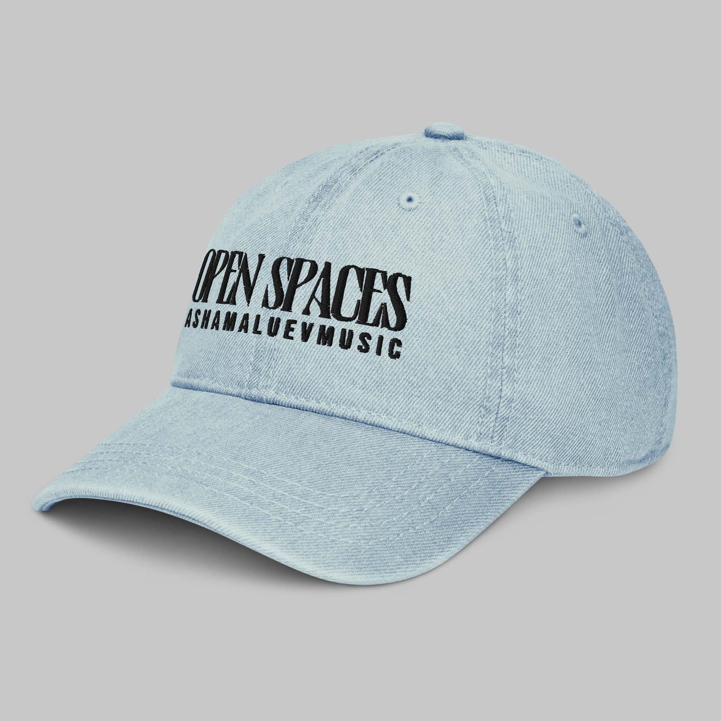 Light blue denim cap with black text 'Open Spaces' and 'AShamaluevMusic' on a gray background