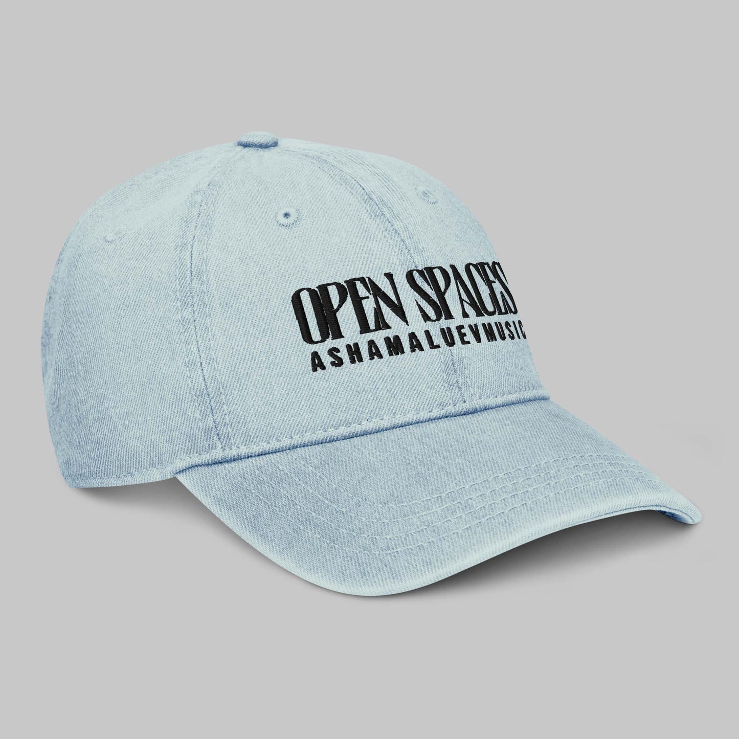 Light blue denim cap with black text 'Open Spaces' and 'AShamaluevMusic' on a gray background
