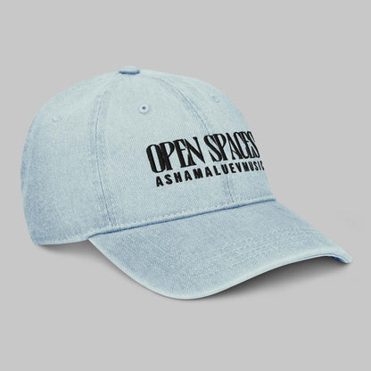Light blue denim cap with black text 'Open Spaces' and 'AShamaluevMusic' on a gray background