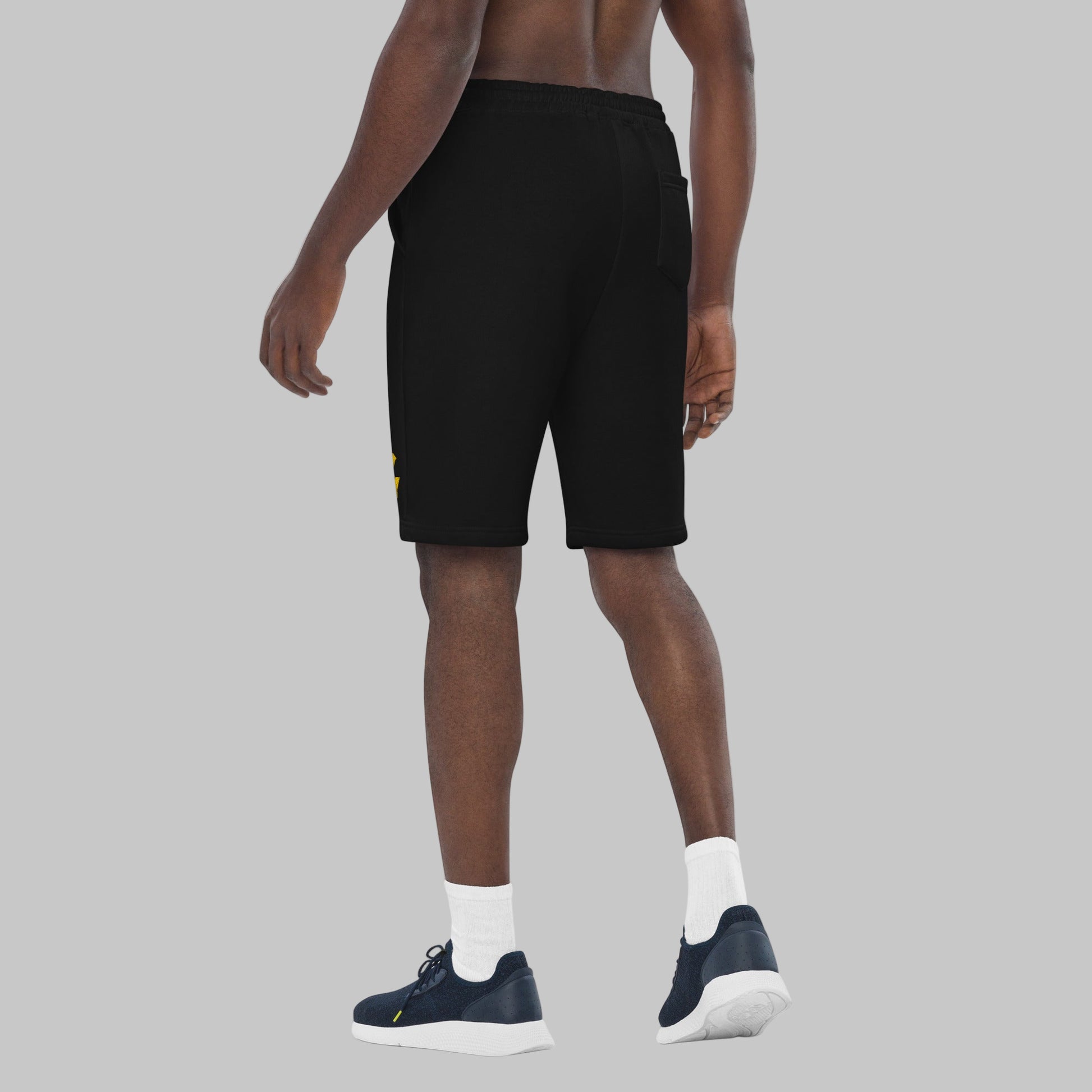 Person wearing black fleece shorts on a grey background