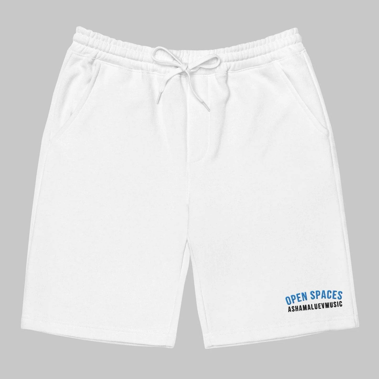 White men's fleece shorts with 'Open Spaces' and 'AShamaluevMusic' text on a gray background