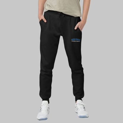 Man wearing black sweatpants with 'Open Spaces' and 'AShamaluevMusic' embroidered on a gray background