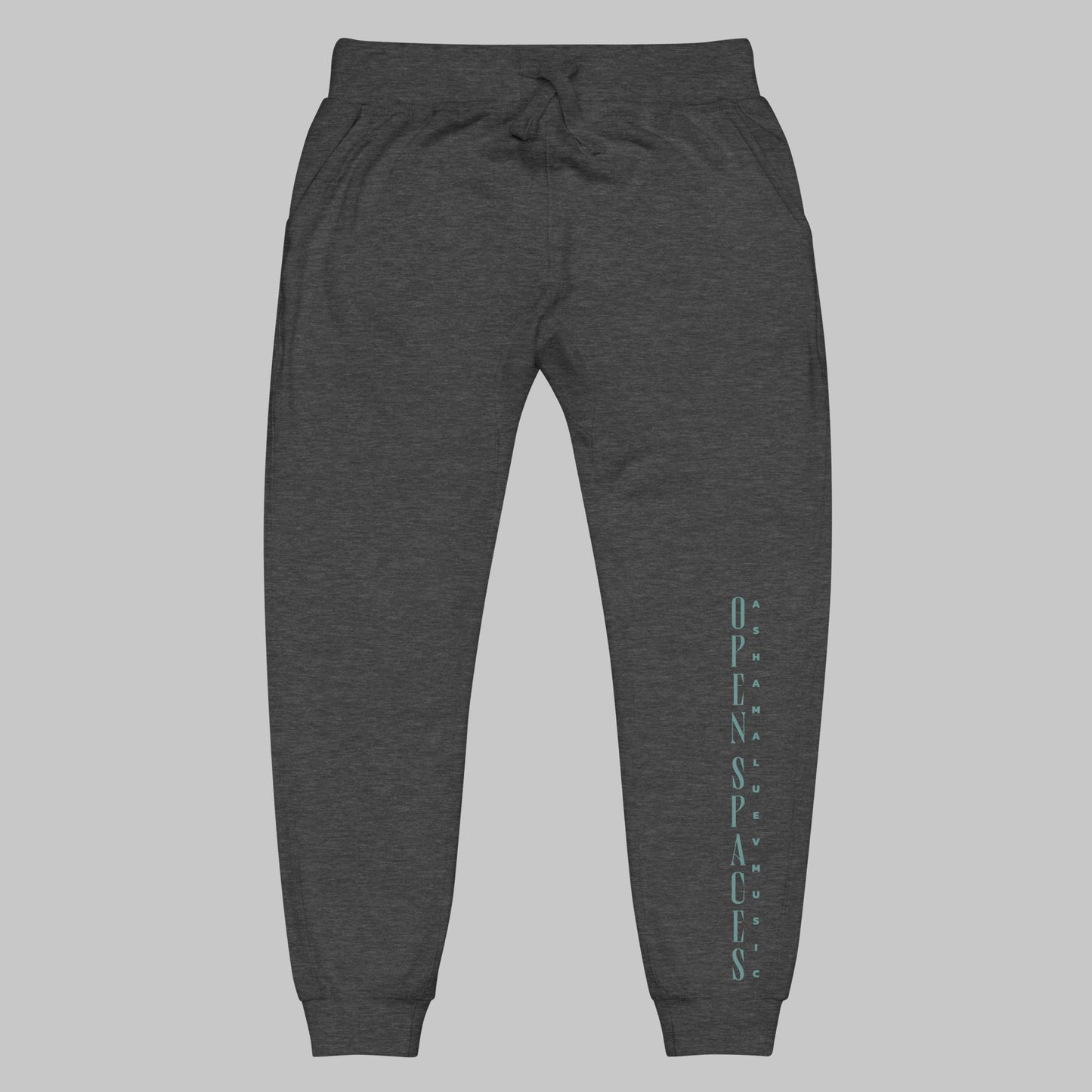 charcoal heather unisex fleece sweatpants with turquoise text 'Open Spaces' and 'AShamaluevMusic' on a gray background.