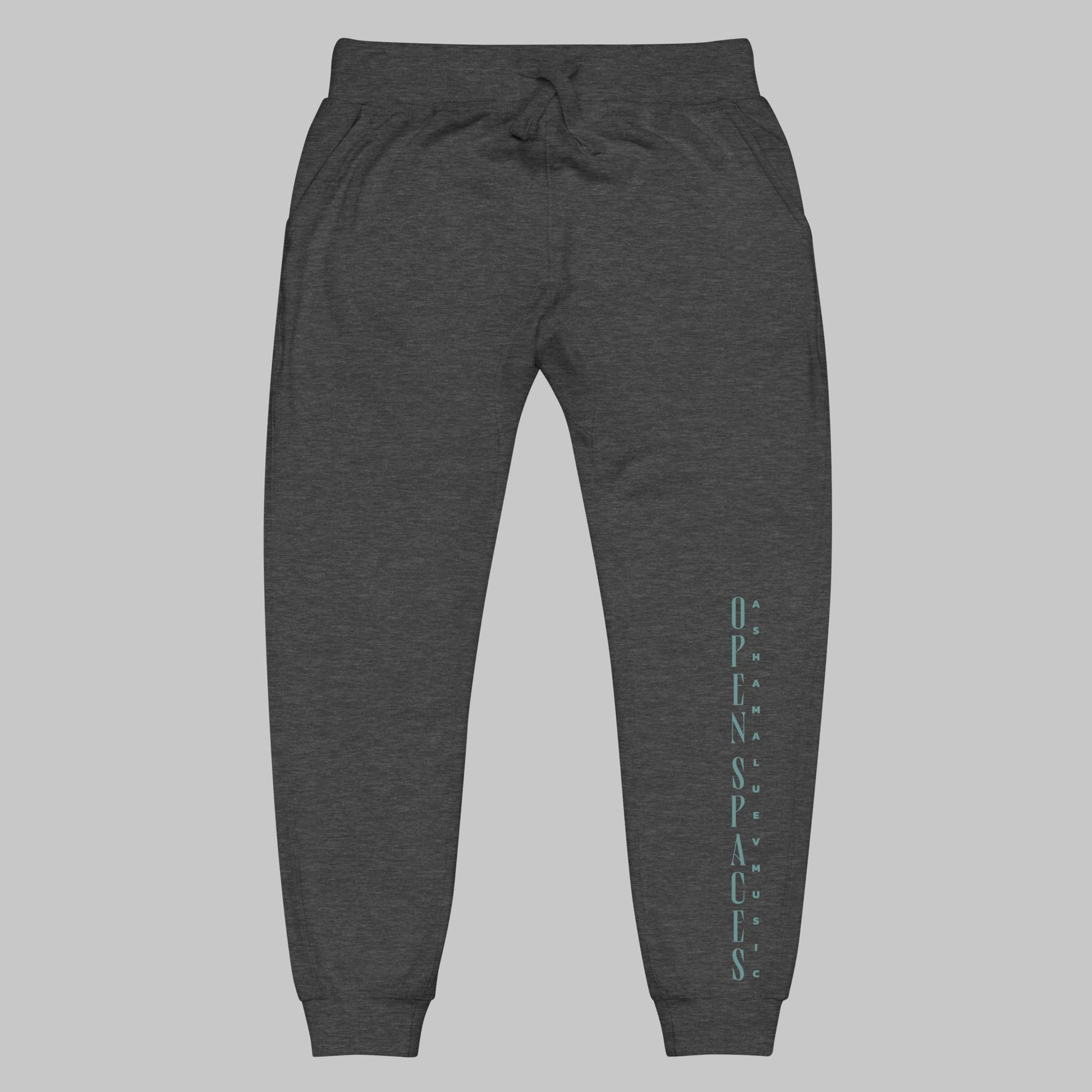 charcoal heather unisex fleece sweatpants with turquoise text 'Open Spaces' and 'AShamaluevMusic' on a gray background.