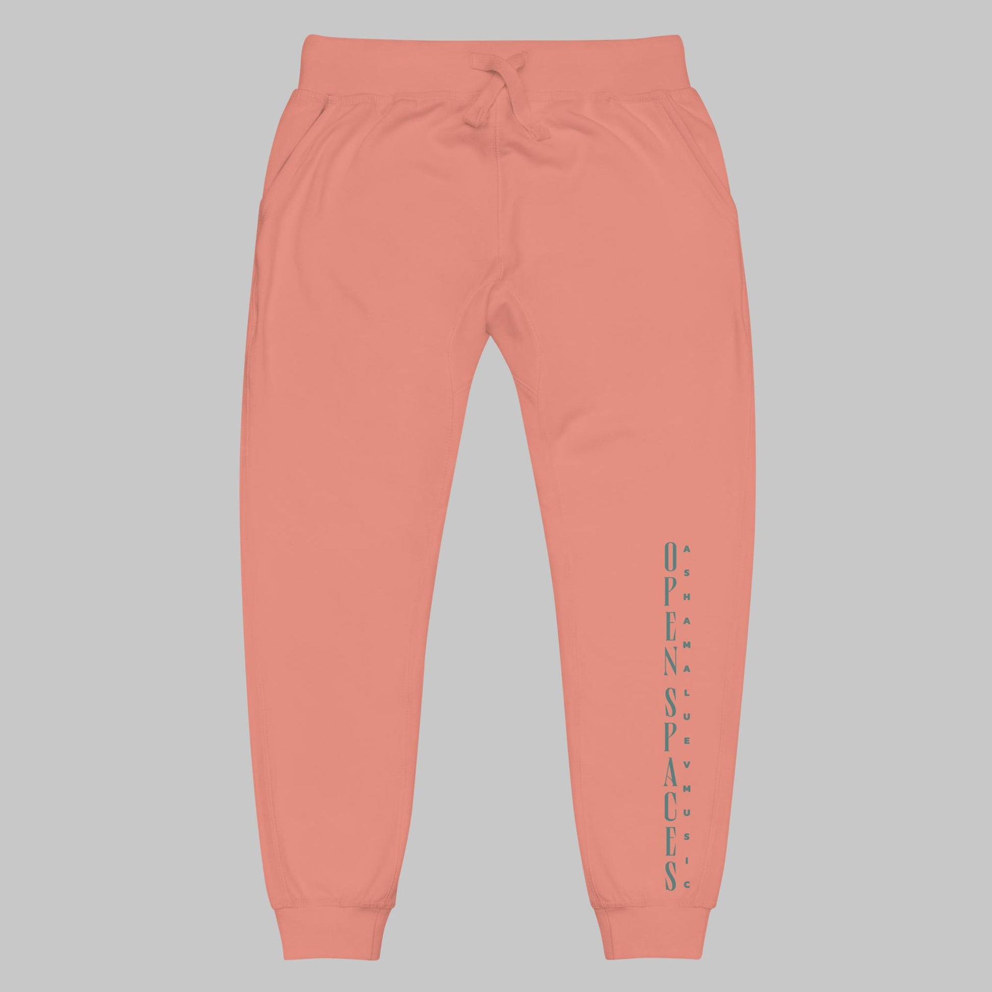 Dusty rose unisex fleece sweatpants with turquoise text 'Open Spaces' and 'AShamaluevMusic' on a gray background.