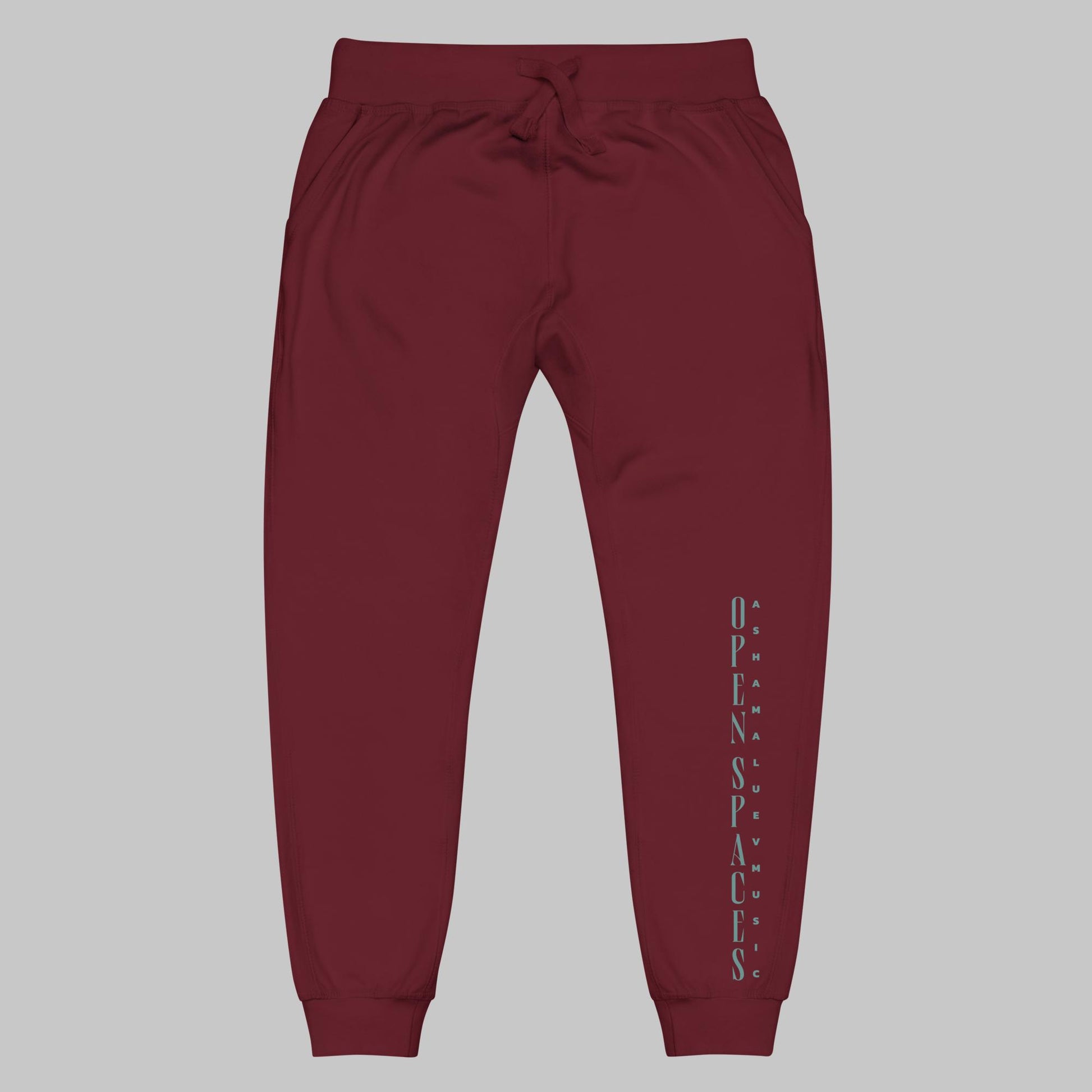 Maroon unisex fleece sweatpants with turquoise text 'Open Spaces' and 'AShamaluevMusic' on a gray background.