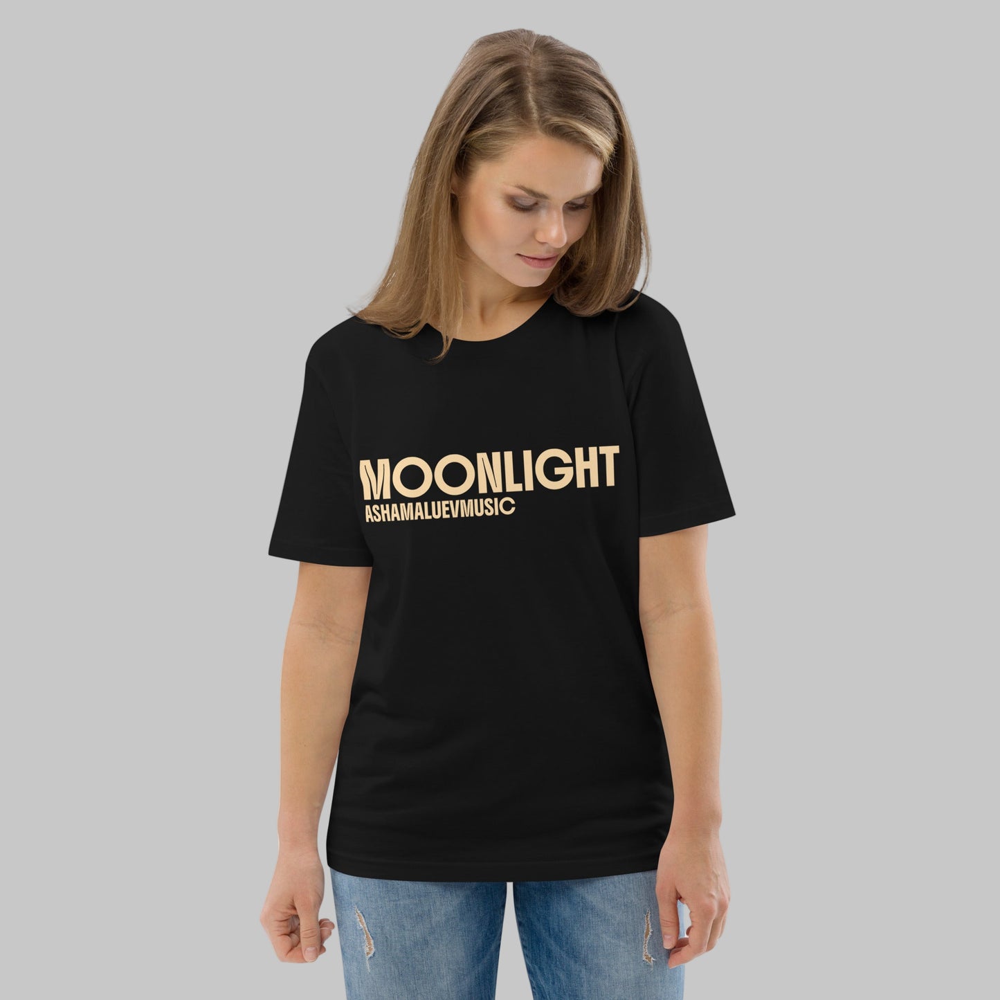 Woman wearing a black organic cotton t-shirt with 'Moonlight' print and AShamaluevMusic logo on a light grey background