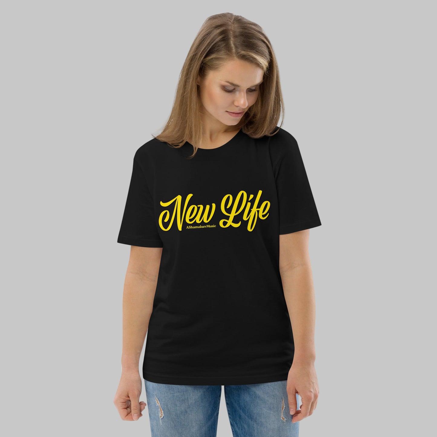 Woman wearing a black organic cotton t-shirt with 'New Life' print and AShamaluevMusic logo in yellow text on a grey background