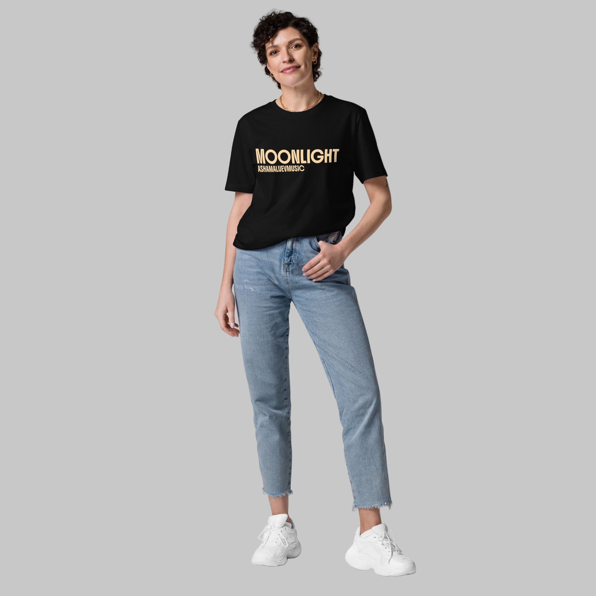 Woman wearing a black organic cotton t-shirt with 'Moonlight' print and AShamaluevMusic logo on a light grey background