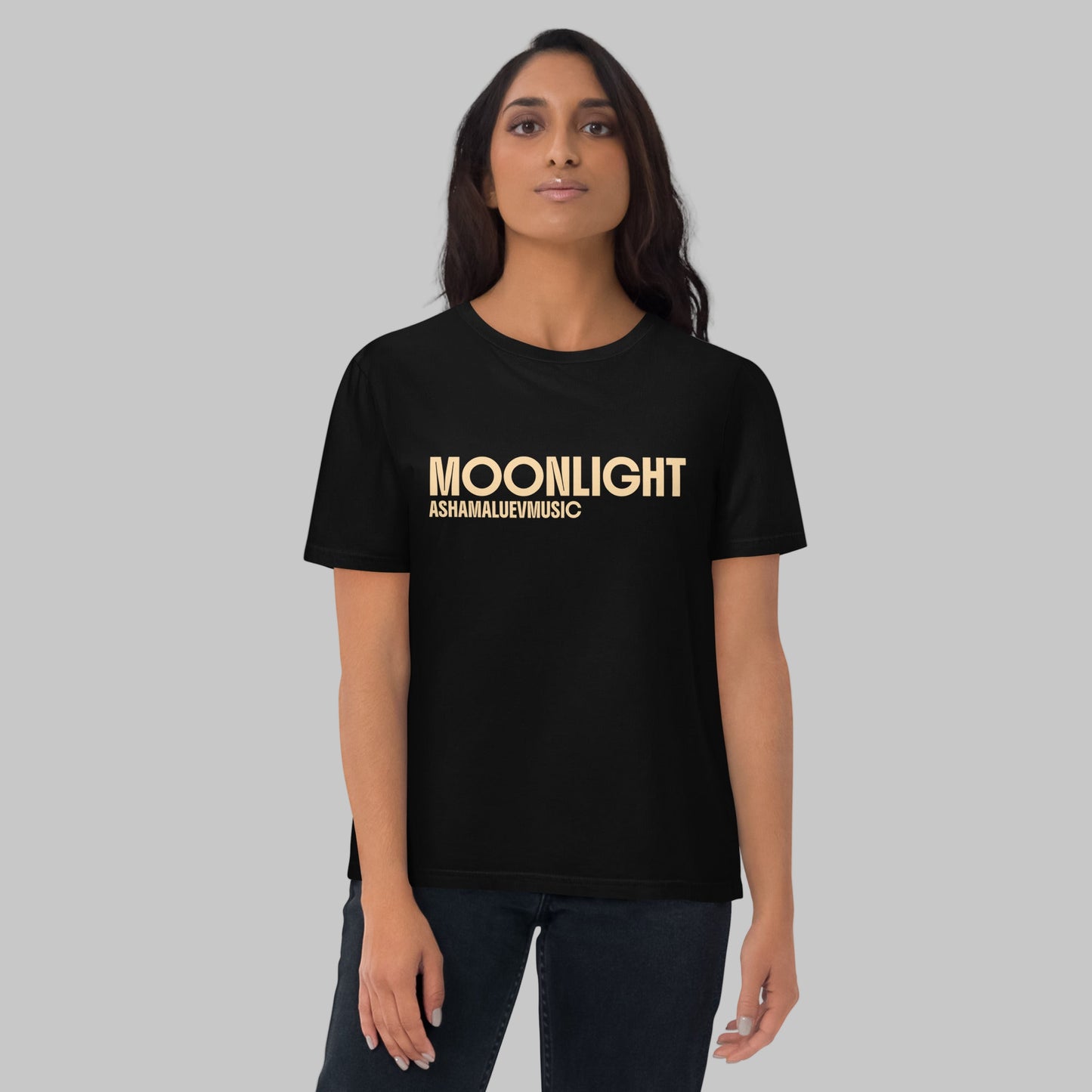 Woman wearing a black organic cotton t-shirt with 'Moonlight' print and AShamaluevMusic logo on a light grey background