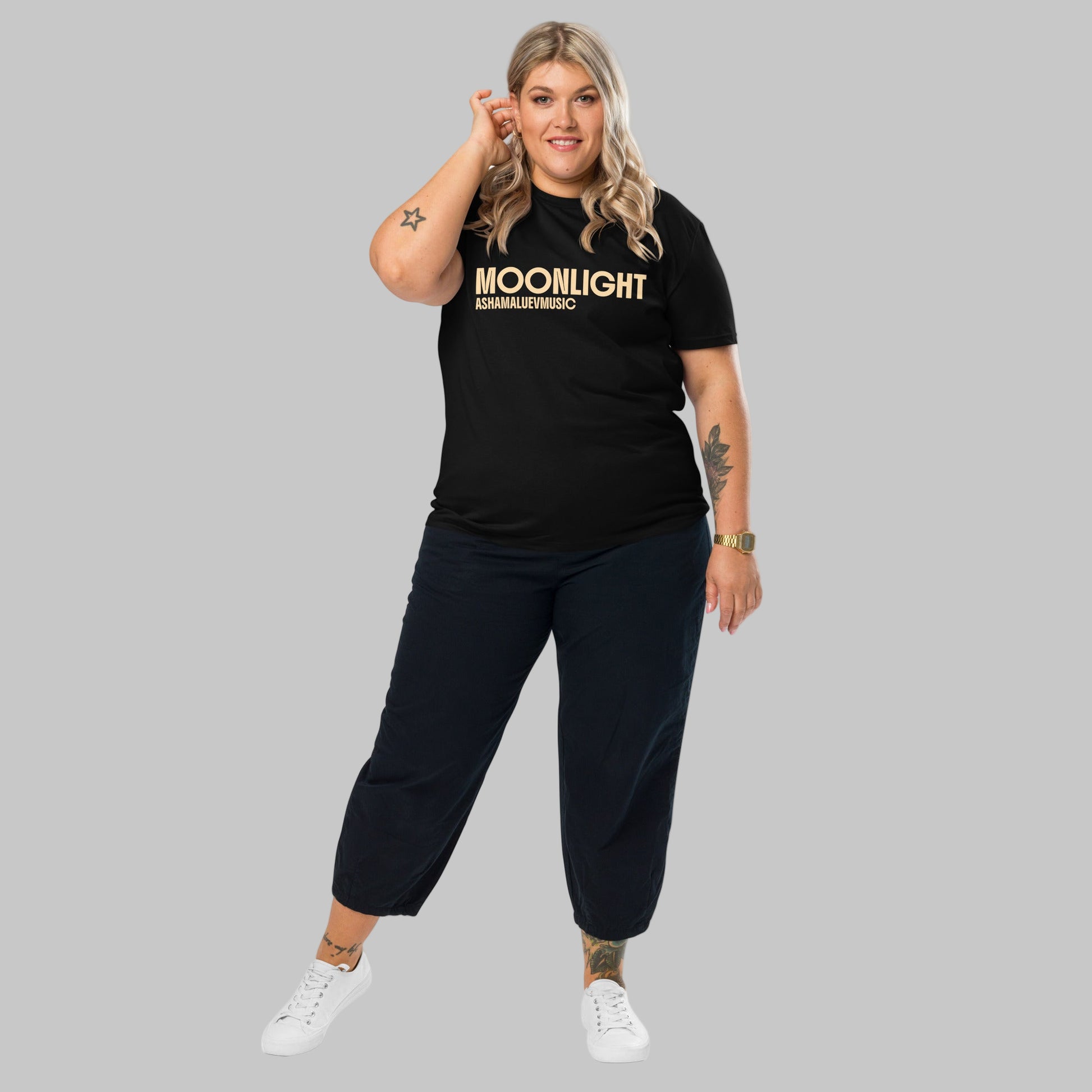 Woman wearing a black organic cotton t-shirt with 'Moonlight' print and AShamaluevMusic logo on a light grey background