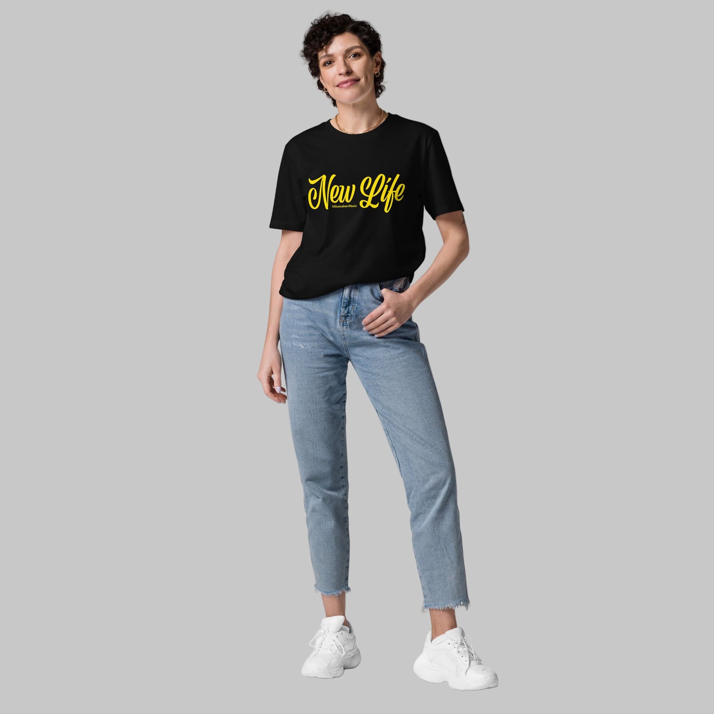 Woman wearing a black organic cotton t-shirt with 'New Life' print and AShamaluevMusic logo in yellow text on a grey background