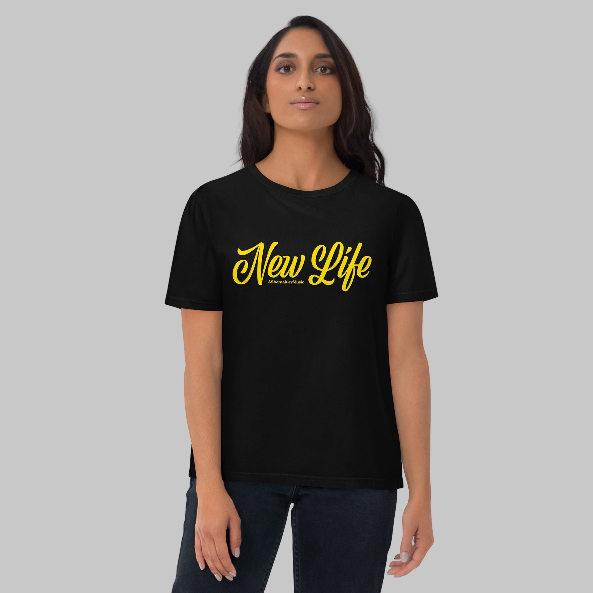 Woman wearing a black organic cotton t-shirt with 'New Life' print and AShamaluevMusic logo in yellow text on a grey background