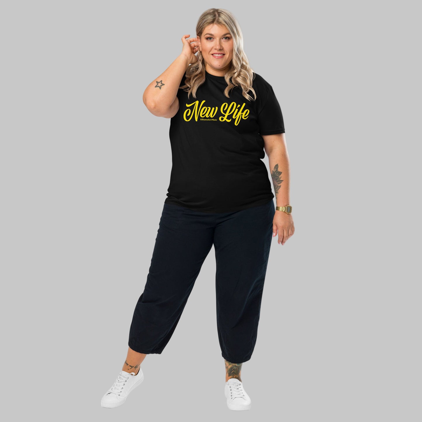 Woman wearing a black organic cotton t-shirt with 'New Life' print and AShamaluevMusic logo in yellow text on a grey background