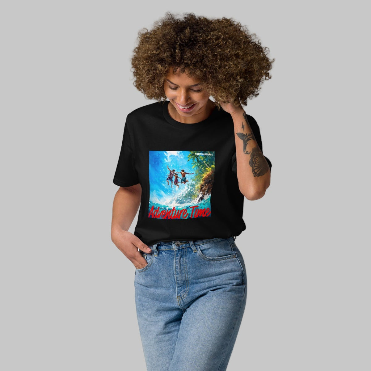 Woman wearing a black t-shirt with a 'Adventure Time' graphic design and AShamaluevMusic logo on a grey background.