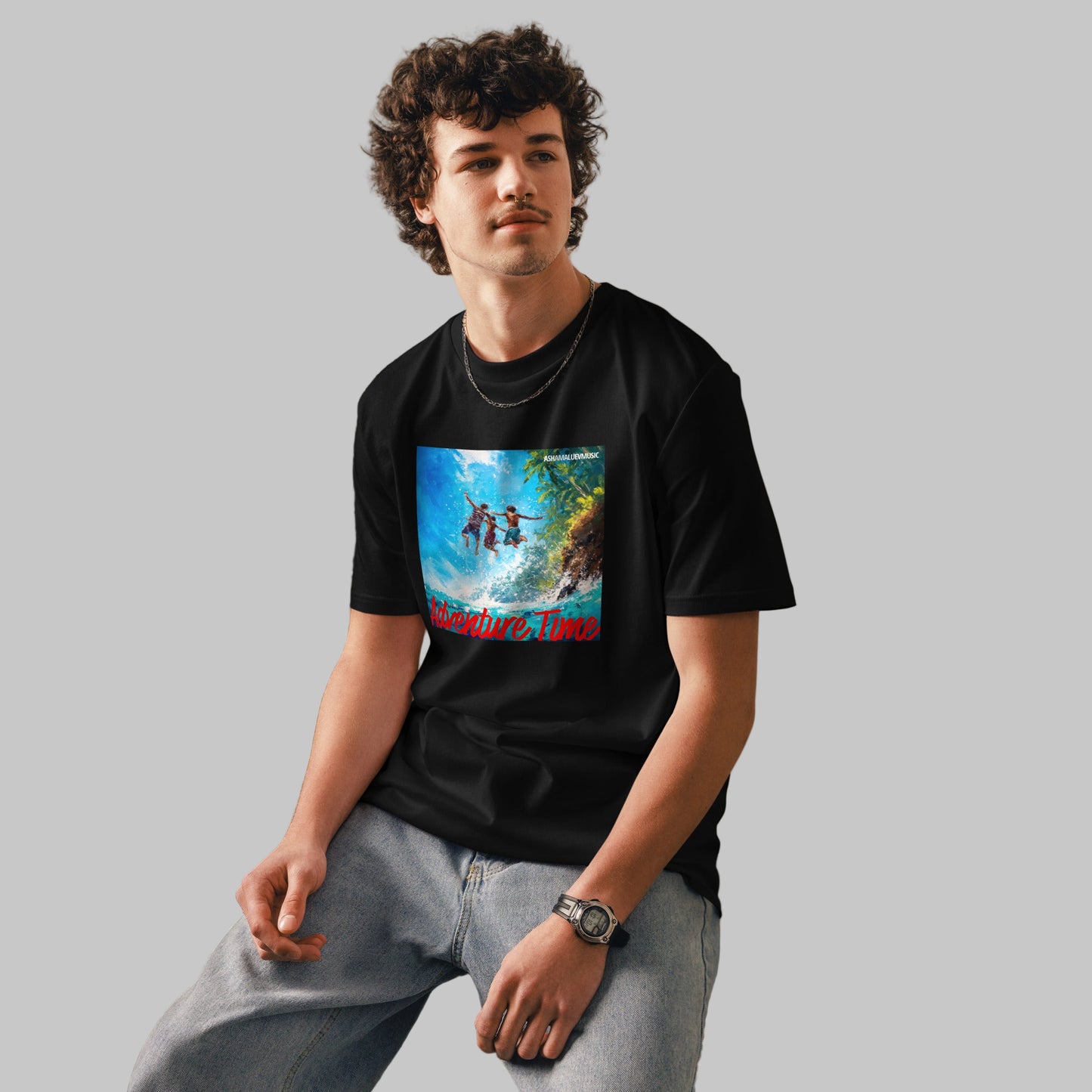 Man wearing a black t-shirt with a 'Adventure Time' graphic design and AShamaluevMusic logo on a grey background.