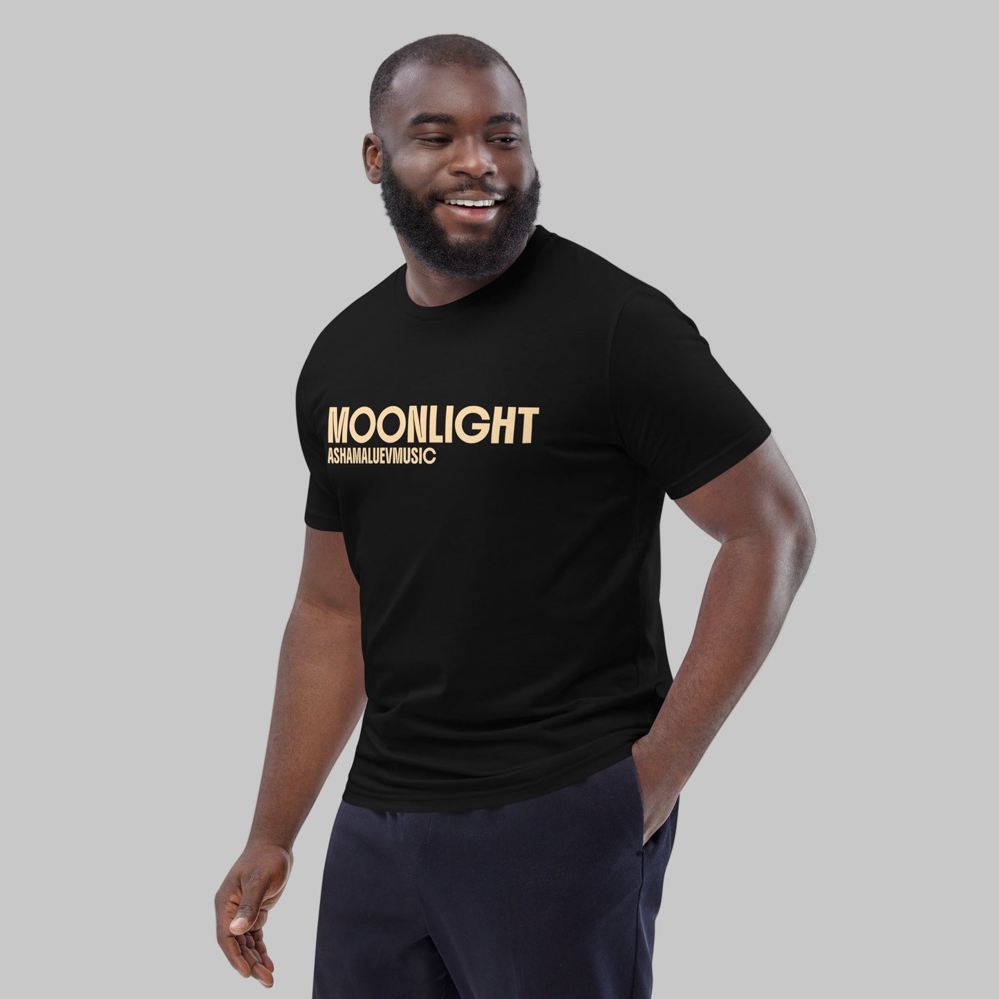 Man wearing a black organic cotton t-shirt with 'Moonlight' print and AShamaluevMusic logo on a light grey background