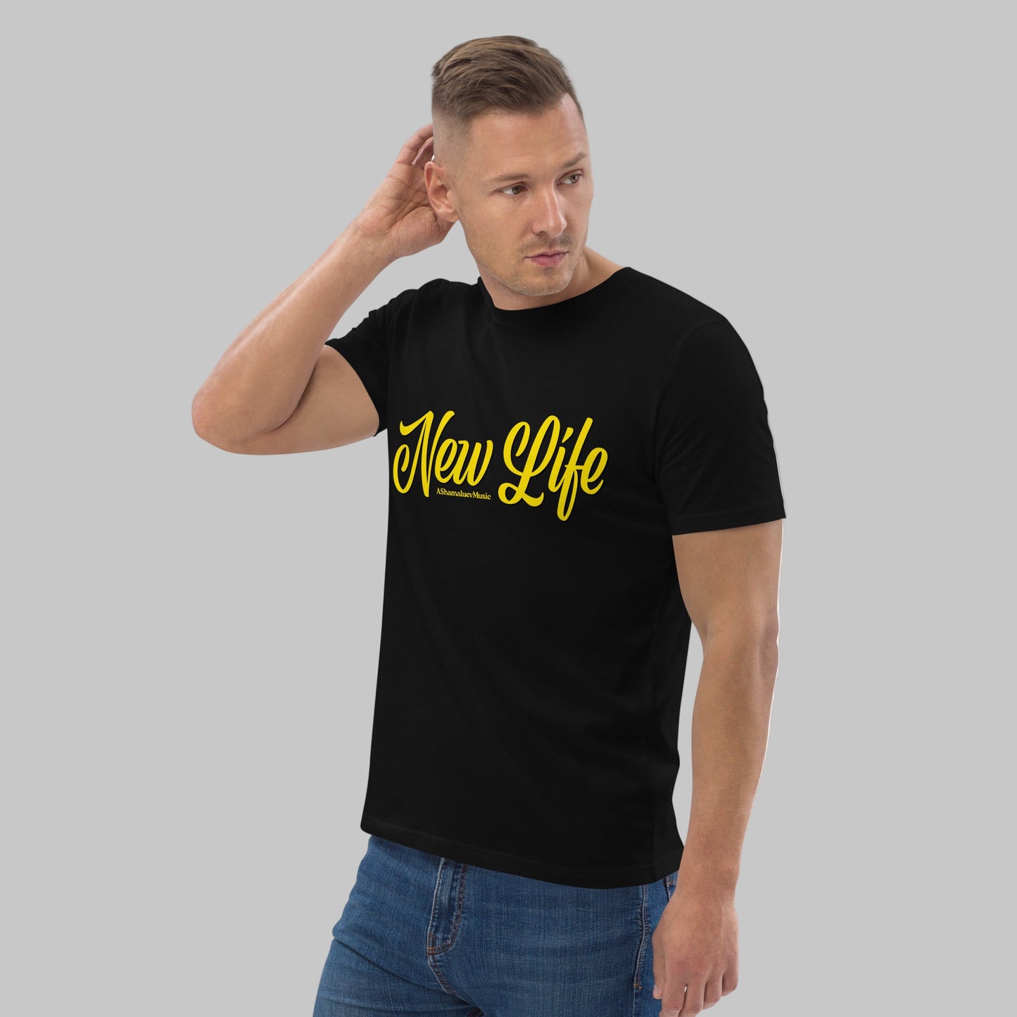Man wearing a black organic cotton t-shirt with 'New Life' print and AShamaluevMusic logo in yellow text on a grey background