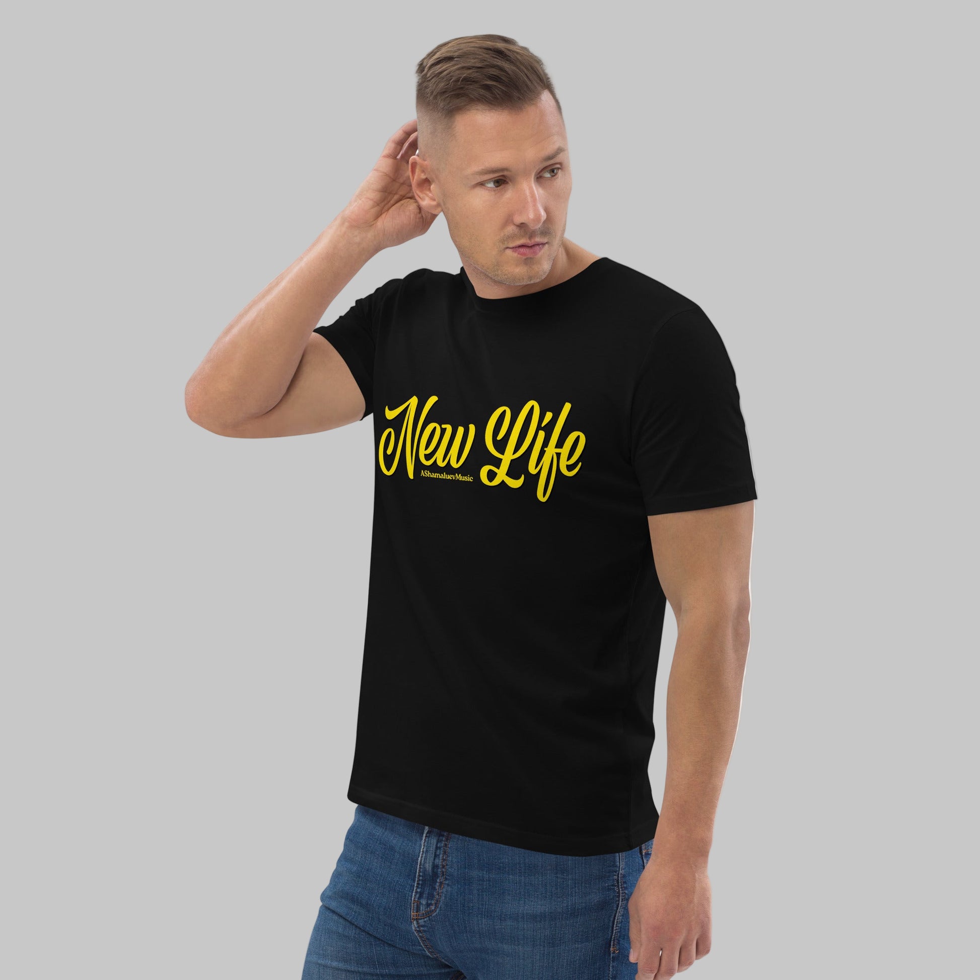 Man wearing a black organic cotton t-shirt with 'New Life' print and AShamaluevMusic logo in yellow text on a grey background