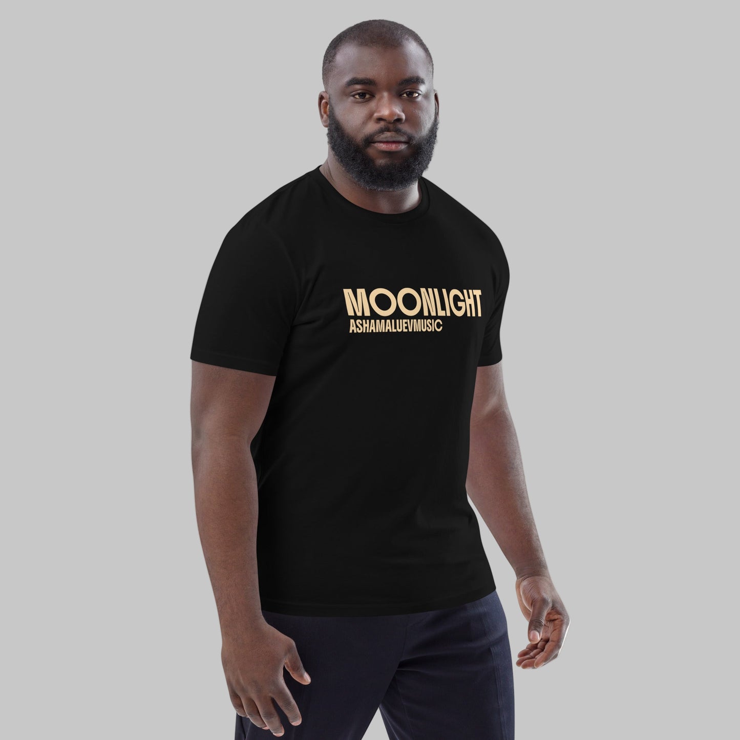 Man wearing a black organic cotton t-shirt with 'Moonlight' print and AShamaluevMusic logo on a light grey background