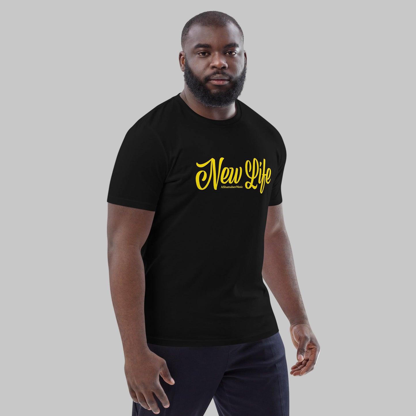 Man wearing a black organic cotton t-shirt with 'New Life' print and AShamaluevMusic logo in yellow text on a grey background