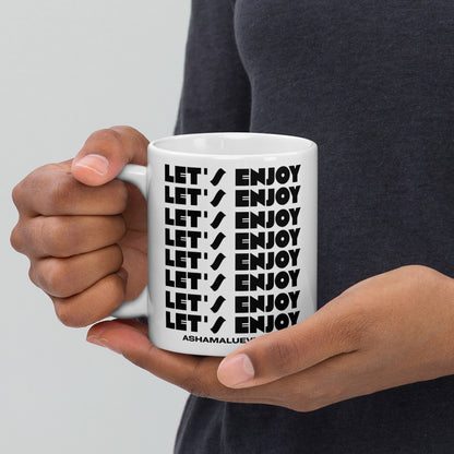 Person holding a white mug with 'LET'S ENJOY' text in black.