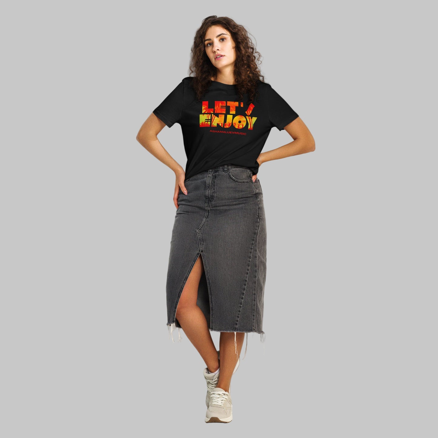 Woman wearing a black t-shirt with 'LET'S ENJOY' text and AShamaluevMusic logo in colorful letters on a grey background