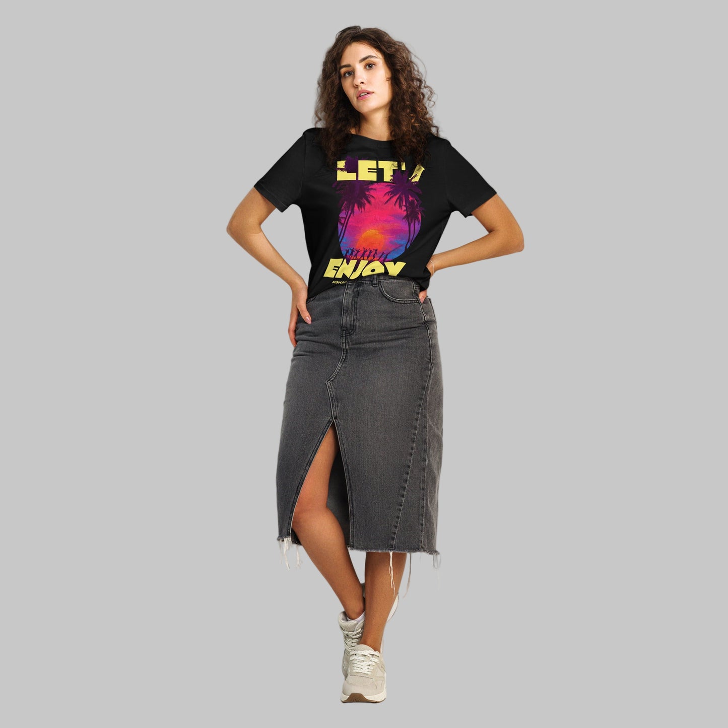 Woman wearing a black t-shirt with a Let's Enjoy print and AShamaluevMusic logo on a grey background