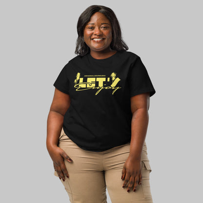 Woman wearing a black t-shirt with yellow graphics 'Let's Enjoy' and AShamaluevMusic logo on a grey background