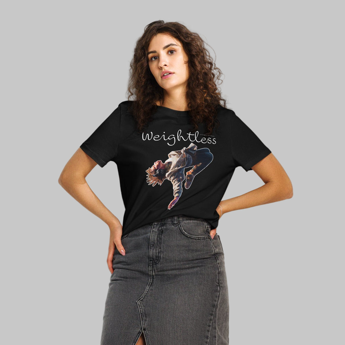 Woman wearing a black t-shirt with a 'Weightless' design and AShamaluevMusic logo on a light grey background
