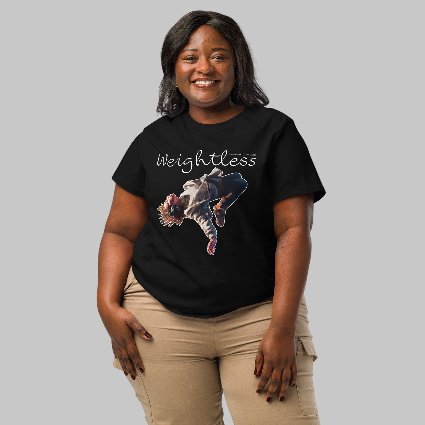 Woman wearing a black t-shirt with a 'Weightless' design and AShamaluevMusic logo on a light grey background