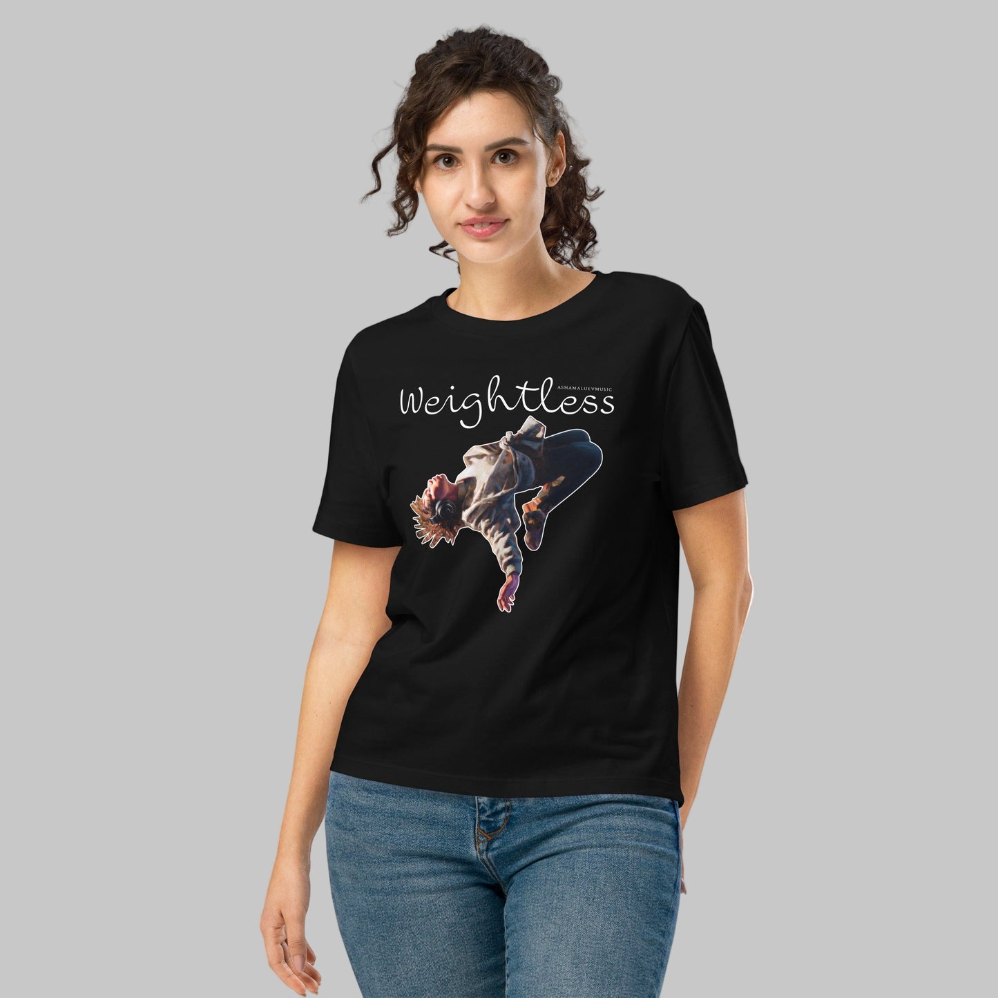 Woman wearing a black t-shirt with a 'Weightless' design and AShamaluevMusic logo on a light grey background
