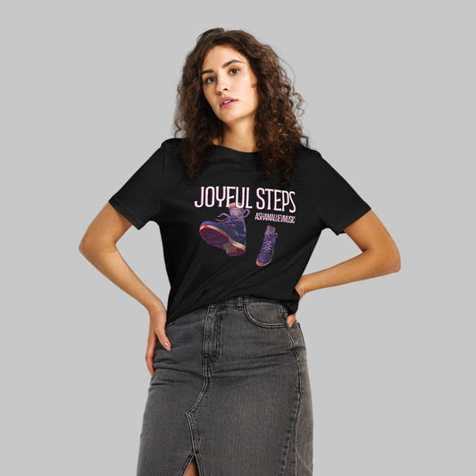 Woman wearing a black t-shirt with 'JOYFUL STEPS' and AShamaluevMusic text and shoe graphics on a gray background