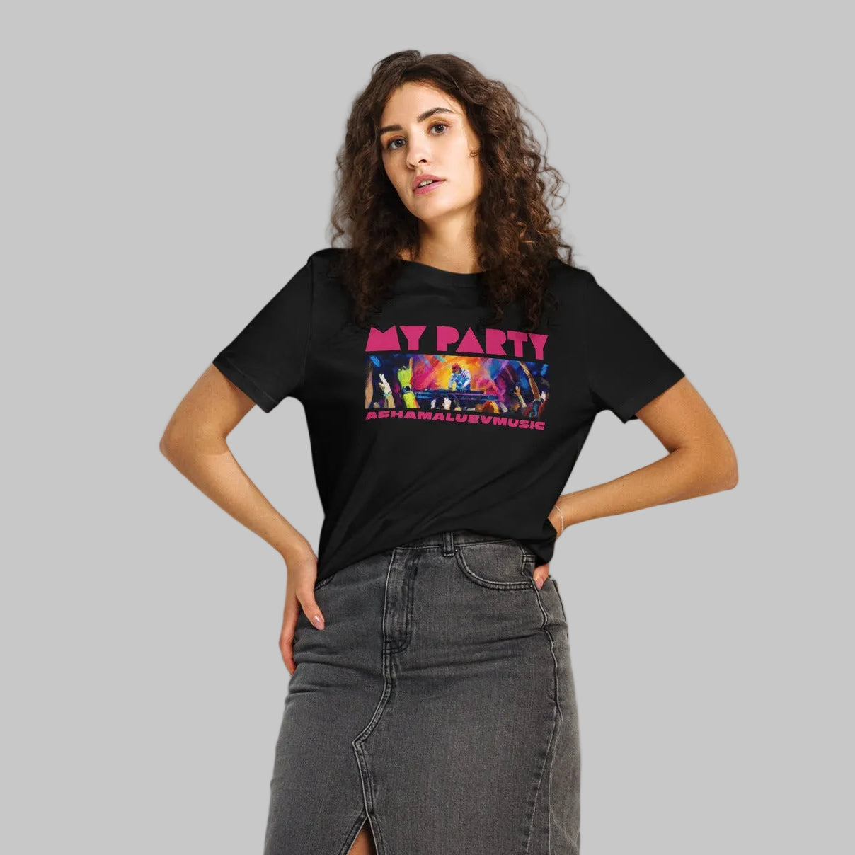 Woman wearing a black t-shirt with graphic and text 'MY PARTY' and 'ASHAMALUEVMUSIC' and a denim skirt on a gray background