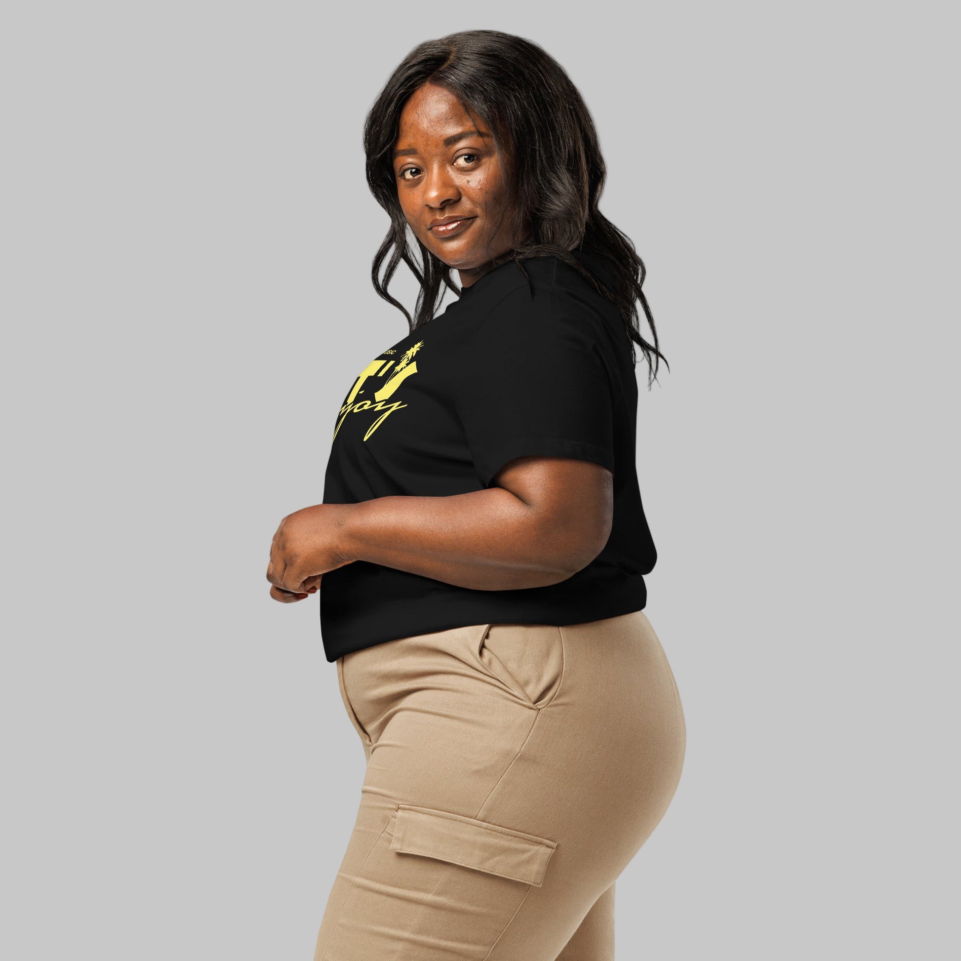 Woman wearing a black t-shirt with yellow graphics 'Let's Enjoy' and AShamaluevMusic logo on a grey background