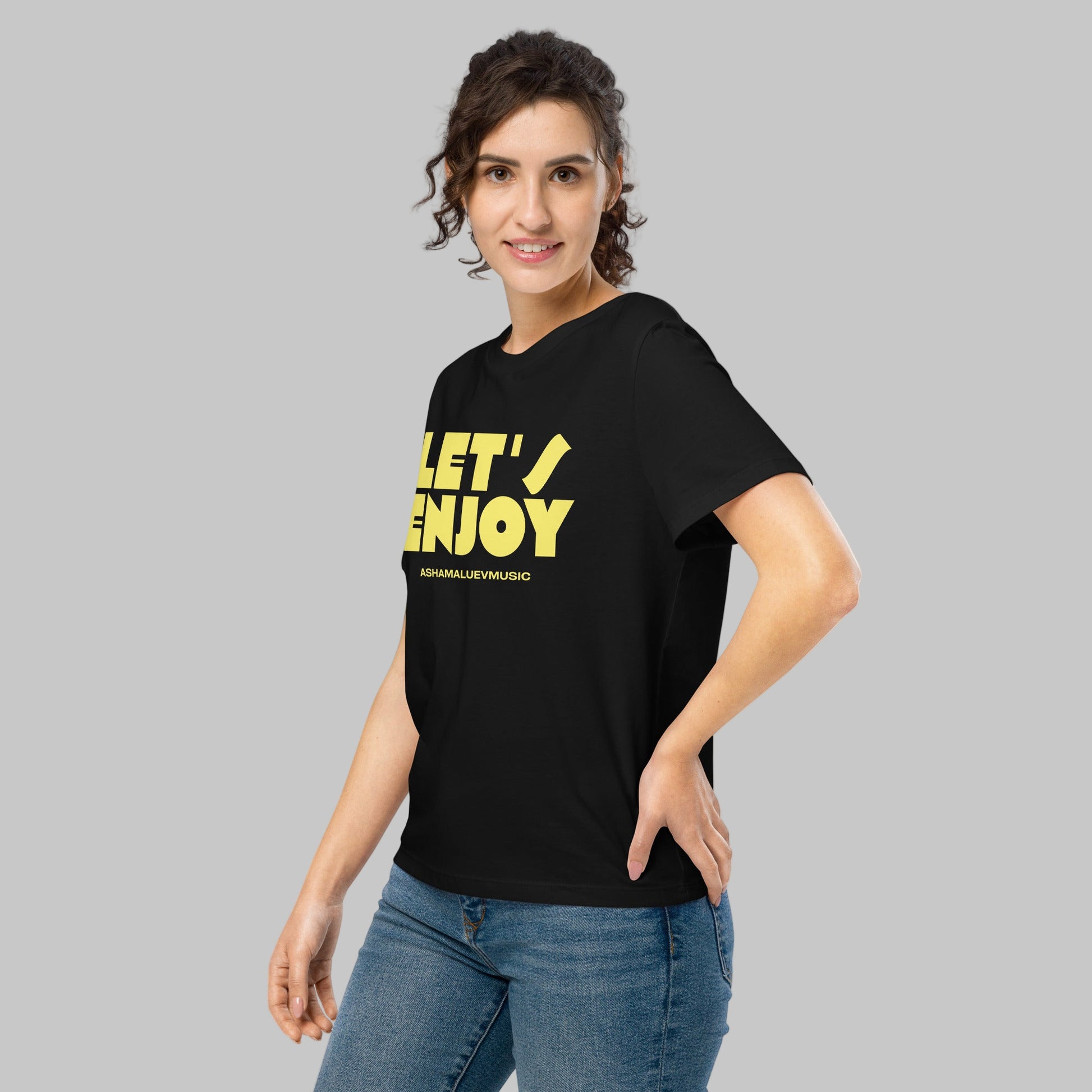 Woman wearing a black t-shirt with a 'Let's Enjoy' print and AShamaluevMusic logo on a grey background